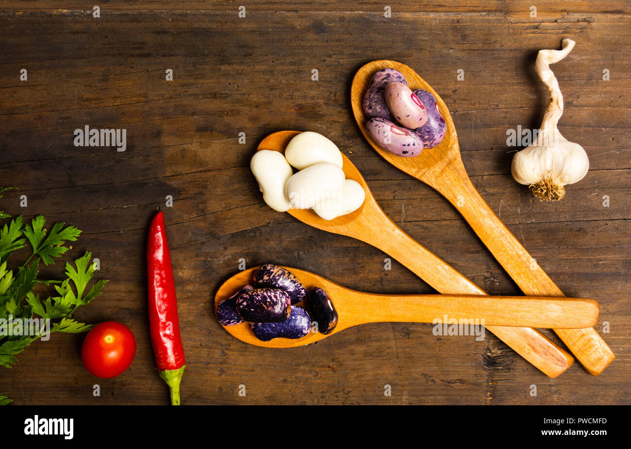 Natürliche weiße Bohnen in hölzerne Löffel auf eine Tabelle, Ansicht von oben Stockfoto