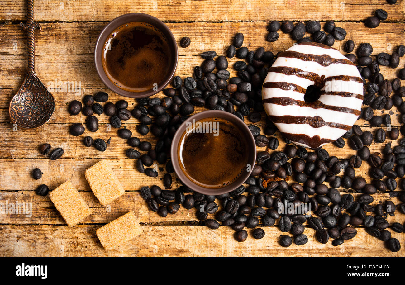 Kaffeebohnen und Getränke mit Donuts, Ansicht von oben Stockfoto