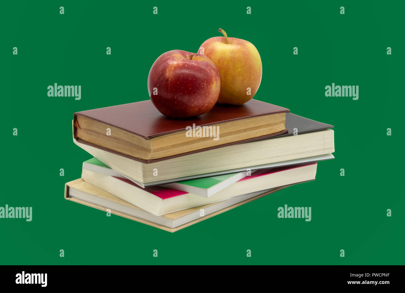 Ein pädagogischer Blick auf zwei Äpfel über wenige Bücher mit einem sauberen und grünen Hintergrund für Chroma Key Stockfoto