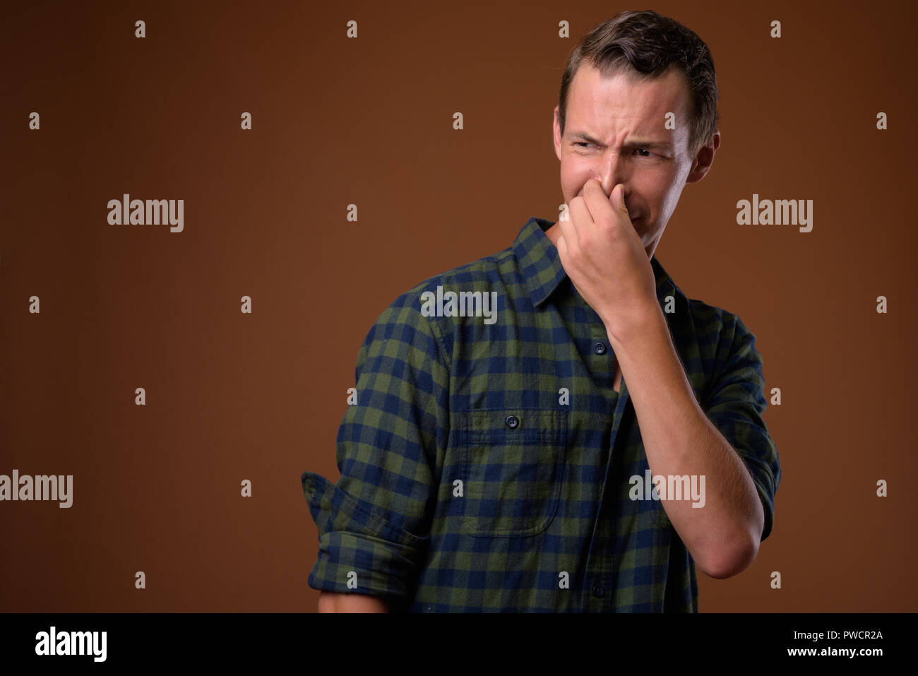 Studio shot des Menschen gegen den braunen Hintergrund Stockfoto