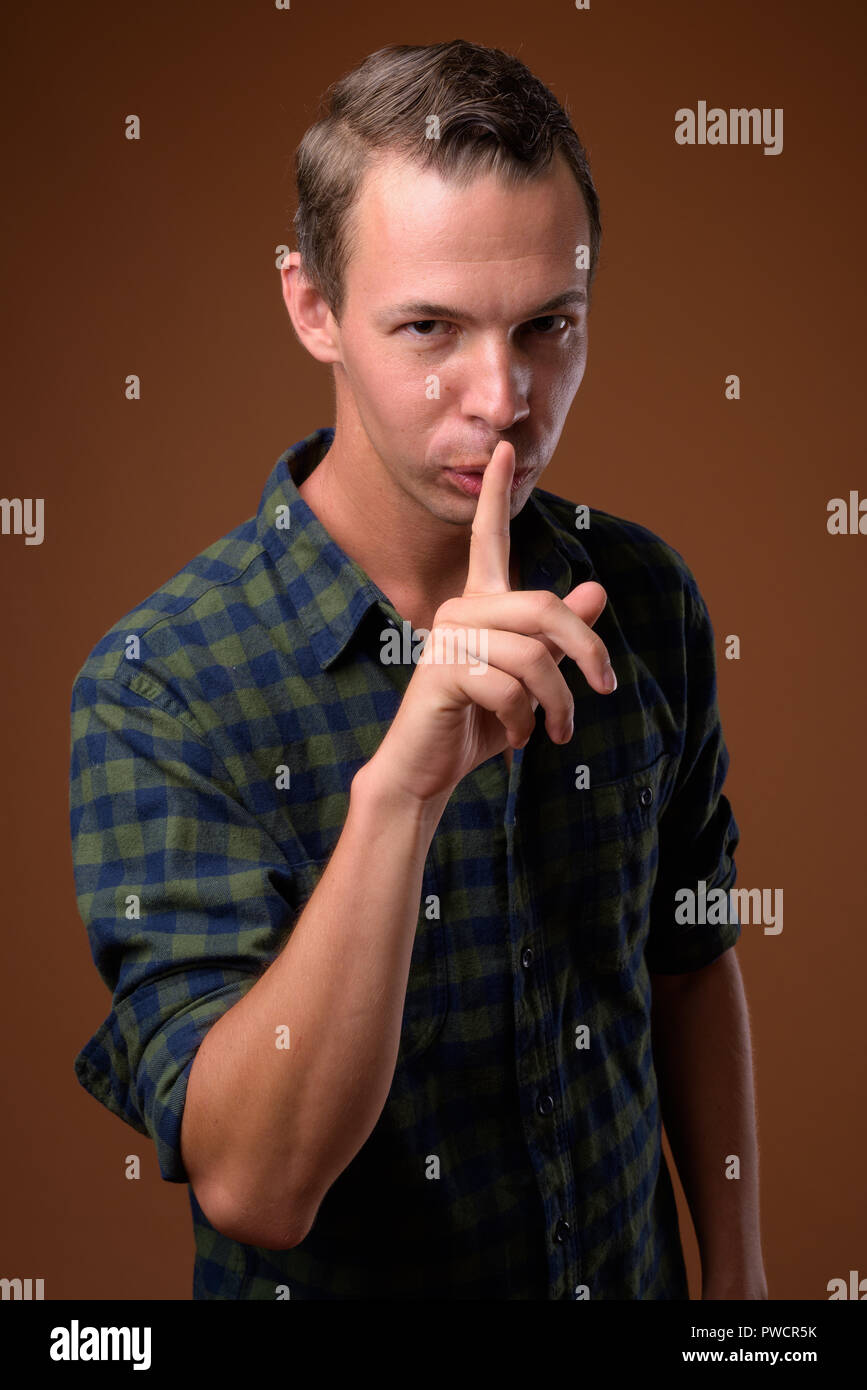 Studio shot des Menschen gegen den braunen Hintergrund Stockfoto