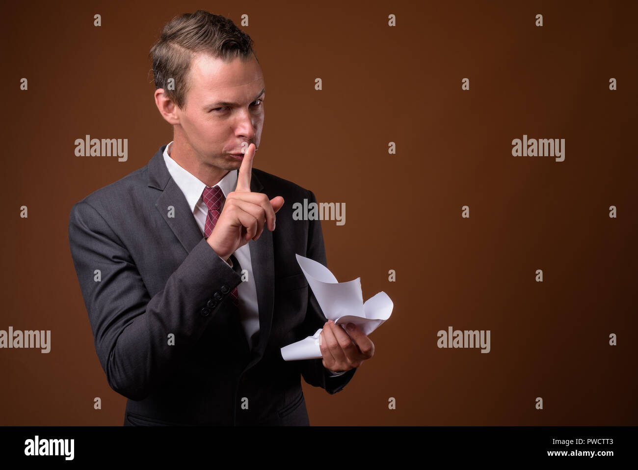 Studio shot der Geschäftsmann gegen braunen Hintergrund Stockfoto