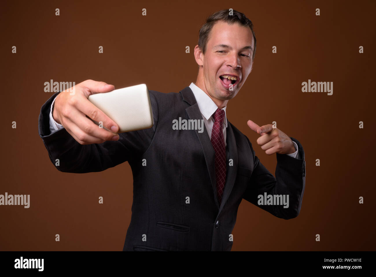 Studio shot der Geschäftsmann gegen braunen Hintergrund Stockfoto