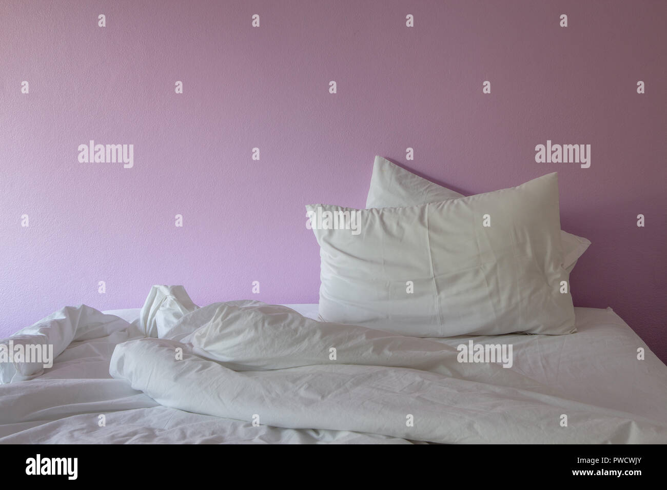 White wrinkle unordentlich Decke und Kissen auf rosa Hintergrund. Stockfoto