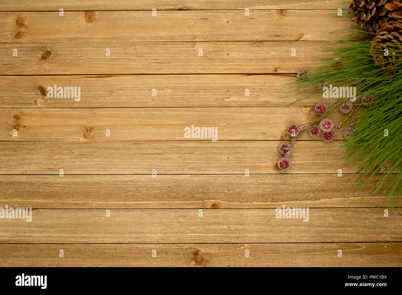 Holiday themed Holz Hintergrund mit frostigen Beeren und Nadeln Stockfoto