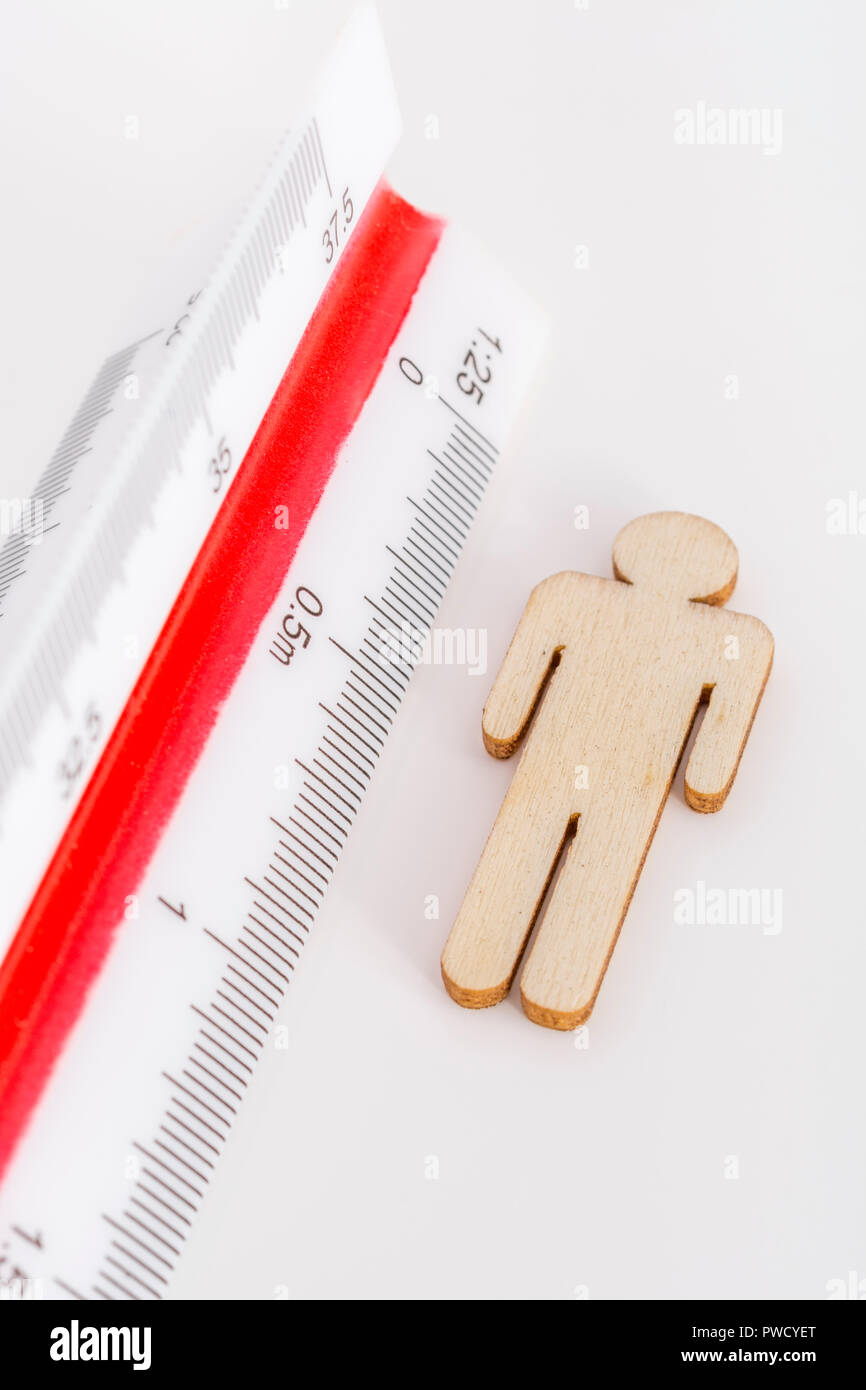 Makro kleine Laser-cut Holzfigur und Lineal. Metapher Messen persönliche Leistung, Demographie Konzept, Produktivität, die Maßnahme von einem Mann bekommen. Stockfoto
