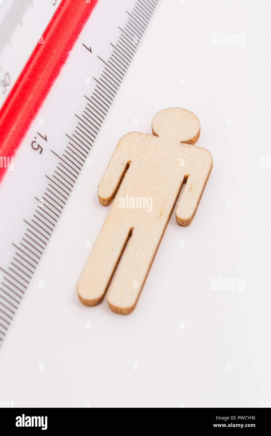 Makro kleine Laser-cut Holzfigur und Lineal. Metapher Messen persönliche Leistung, Demographie Konzept, Produktivität, die Maßnahme von einem Mann bekommen. Stockfoto