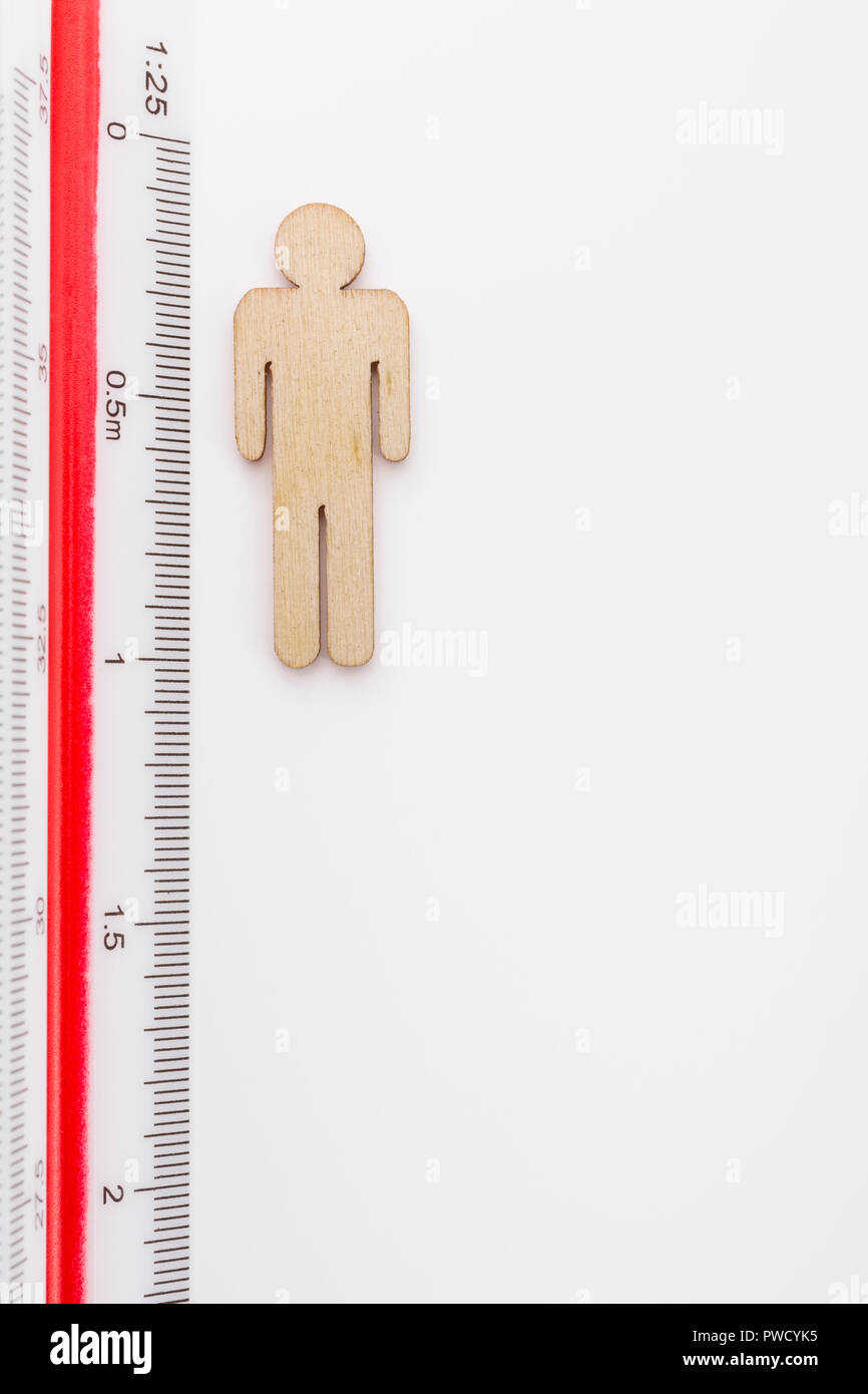 Makro kleine Laser-cut Holzfigur und Lineal. Metapher Messen persönliche Leistung, Demographie Konzept, Produktivität, die Maßnahme von einem Mann bekommen. Stockfoto