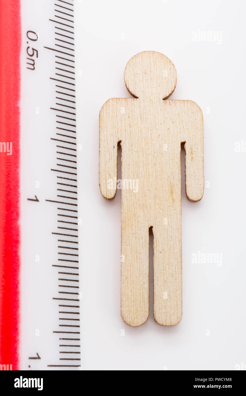 Makro kleine Laser-cut Holzfigur und Lineal. Metapher Messen persönliche Leistung, Demographie Konzept, Produktivität, die Maßnahme von einem Mann bekommen. Stockfoto