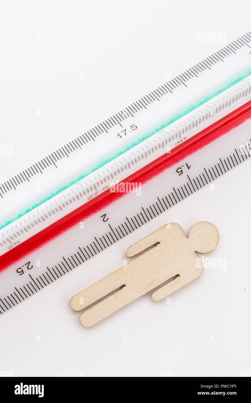 Makro kleine Laser-cut Holzfigur und Lineal. Metapher Messen persönliche Leistung, Demographie Konzept, Produktivität, die Maßnahme von einem Mann bekommen. Stockfoto