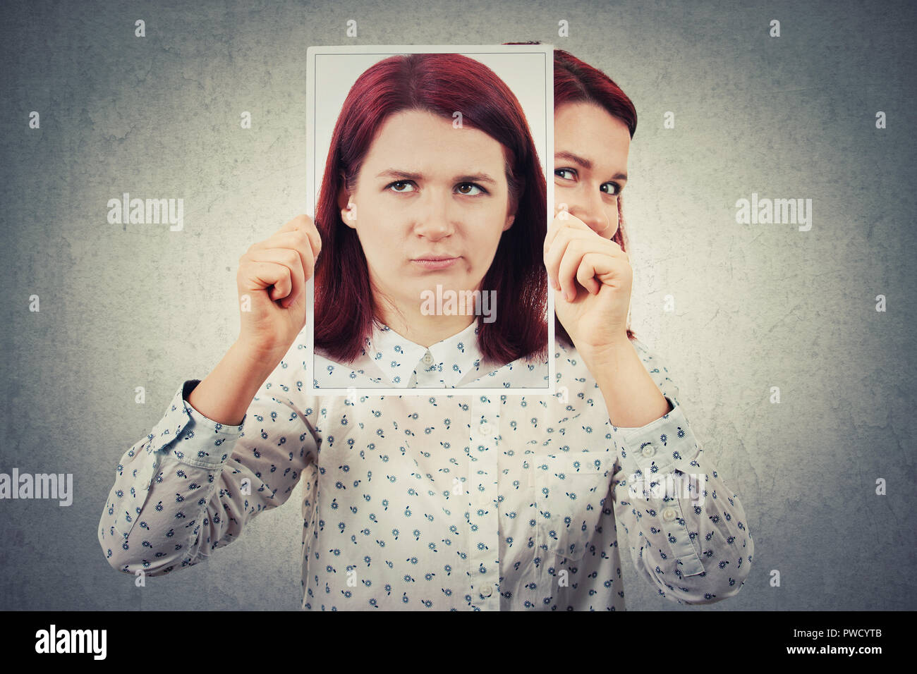 Geschäftsfrau ausblenden Gesicht hinter einem Foto Blatt im Hochformat mit frustriert Emotion. Undercover wie eine Maske echte Persönlichkeit zu verbergen und eine gefälschte iden erstellen Stockfoto