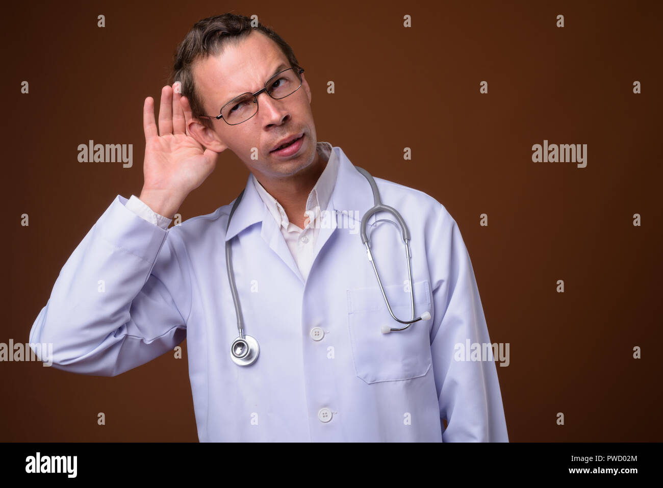 Studio shot der Mann Arzt gegen braunen Hintergrund Stockfoto
