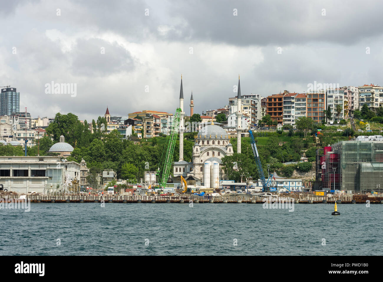 Baumaschinen durch den Bosporus mit Moschee und andere Gebäude im Hintergrund, Istanbul, Türkei Stockfoto