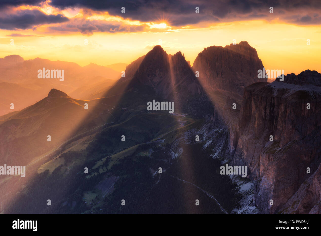 Sonnenstrahlen Filter zwischen stürmischen Wolken bei Sonnenuntergang mit langkofel Gruppe in den Vordergrund. Val di Fassa, Trentino, Dolomiten, Italien, Europa. Stockfoto