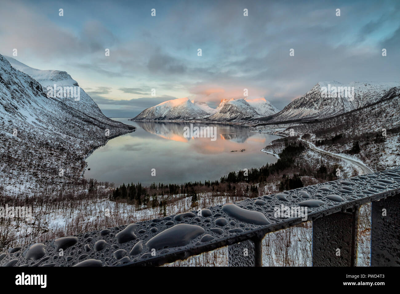 Tropfen Wasser Rahmen die schneebedeckten Gipfel im kalten Meer bei Sonnenuntergang Bergsbotn Senja Troms County Norwegen Europa Stockfoto