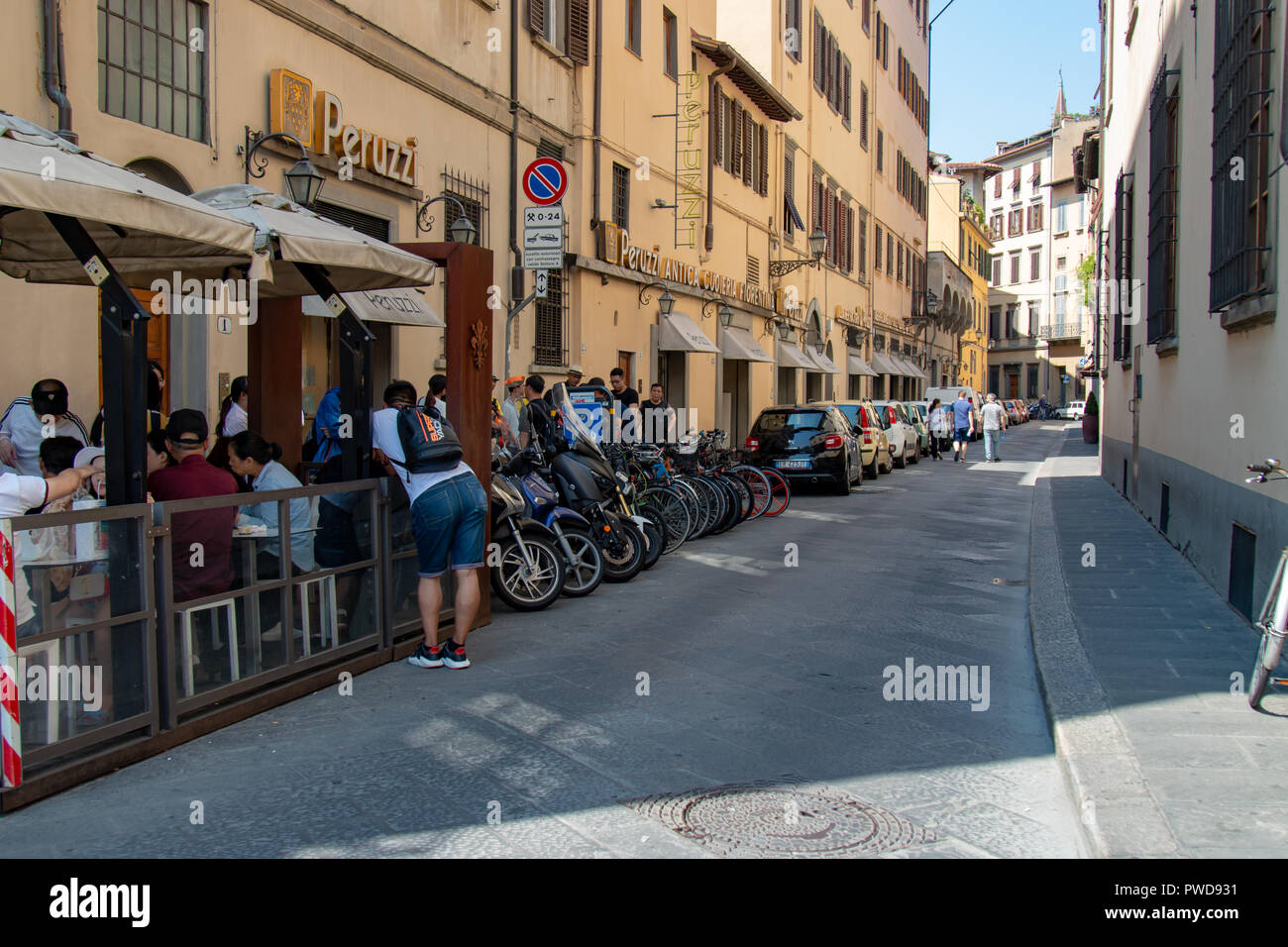 Touristen und Motorräder säumen die Straßen in Florenz, Italien, im Sommer. Stockfoto