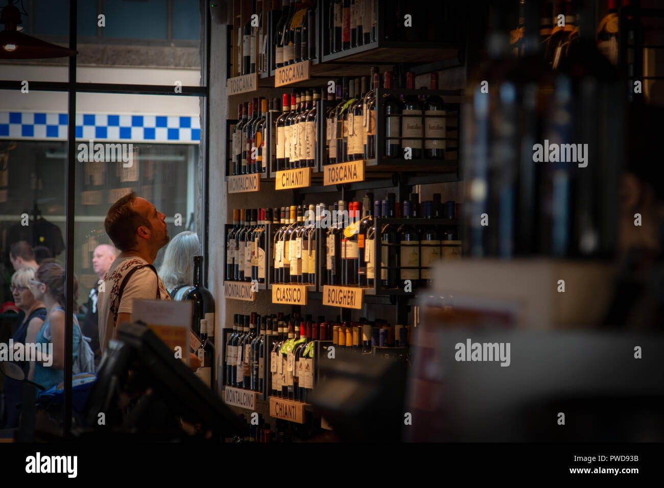 Ein Mann sucht den Wein in einem Geschäft in Florenz, Italien. Stockfoto
