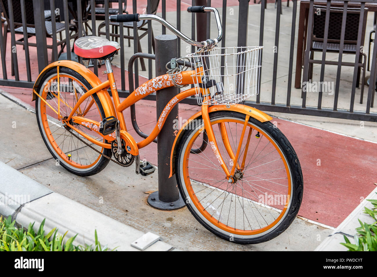 Orange Fahrrad ausserhalb von Store gesperrt Stockfoto