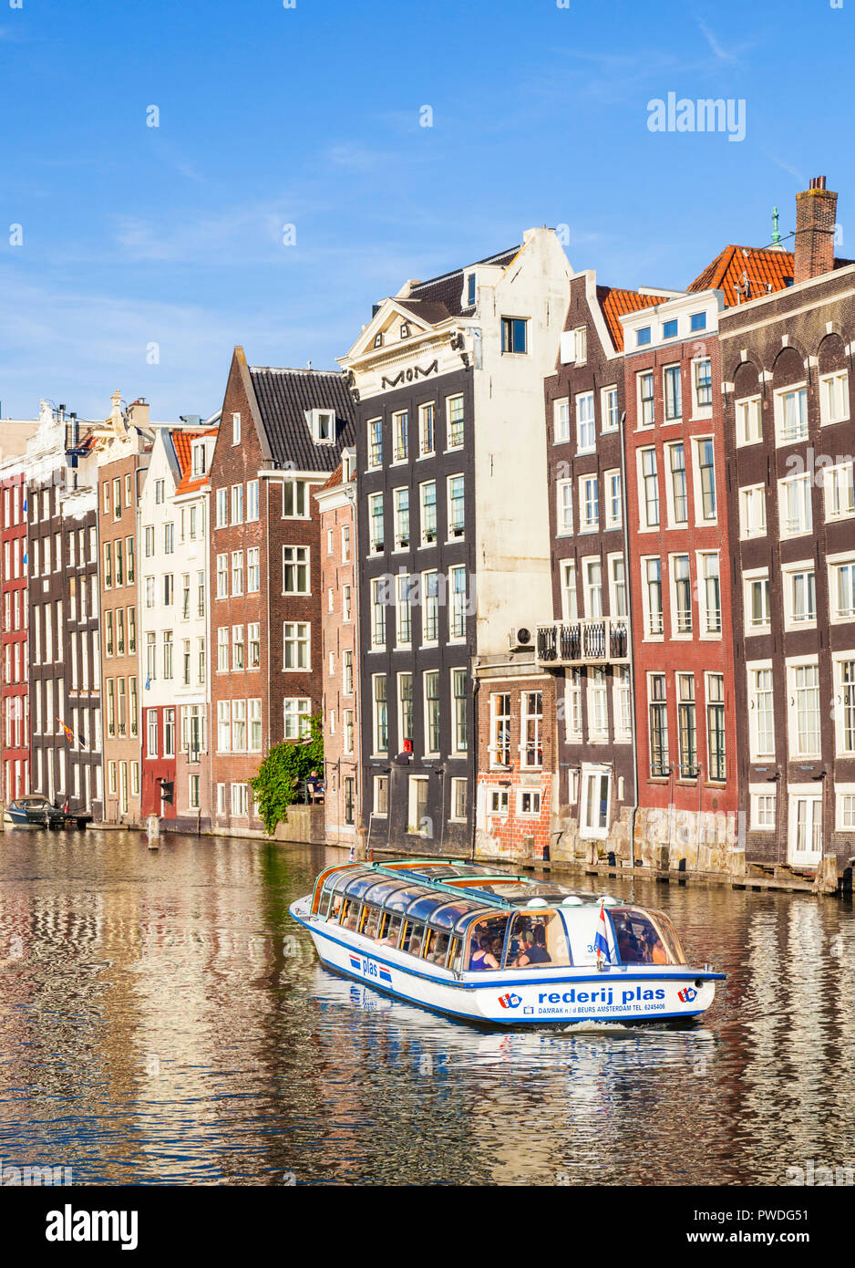 Amsterdam Damrak Häuser auf ein teilweise Kanal mit einem Boot, niederländische Architektur durch den Kanal Damrak Amsterdam Holland EU gefüllt Stockfoto