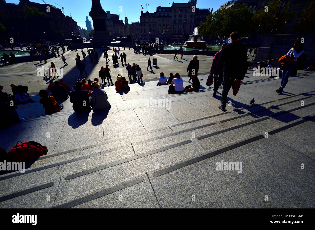 Leute, Trafalgar Square, London, England, UK. Mit Hintergrundbeleuchtung Stockfoto
