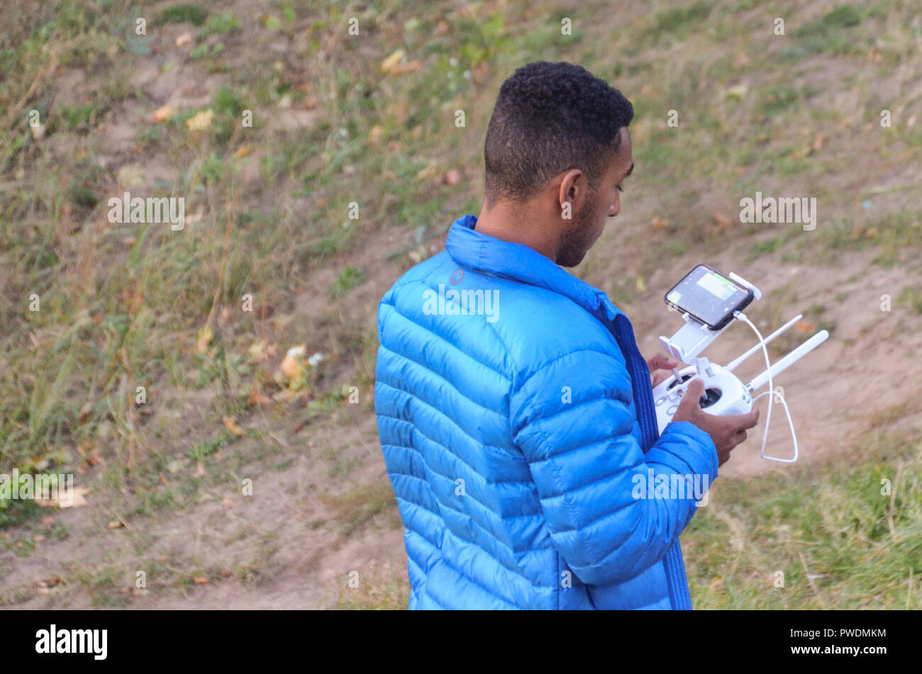 Mann in der blauen Jacke, die eine Drohne Stockfoto