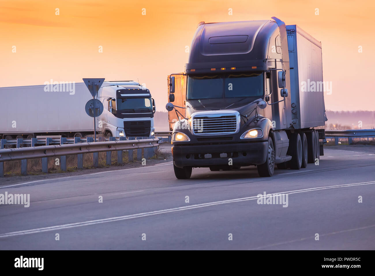 Lkw fährt auf der Autobahn am Abend bei Sonnenuntergang Stockfoto