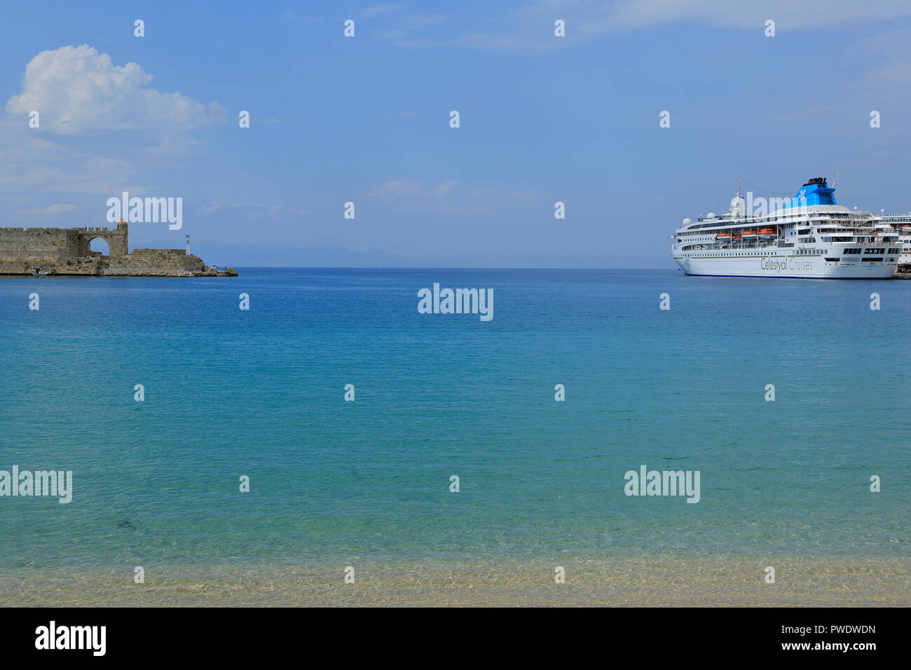 Blick über den Mandraki Hafen auf der Insel Rhodos, wo der mittelalterlichen historischen Gebäuden noch sichtbar sind. Stockfoto