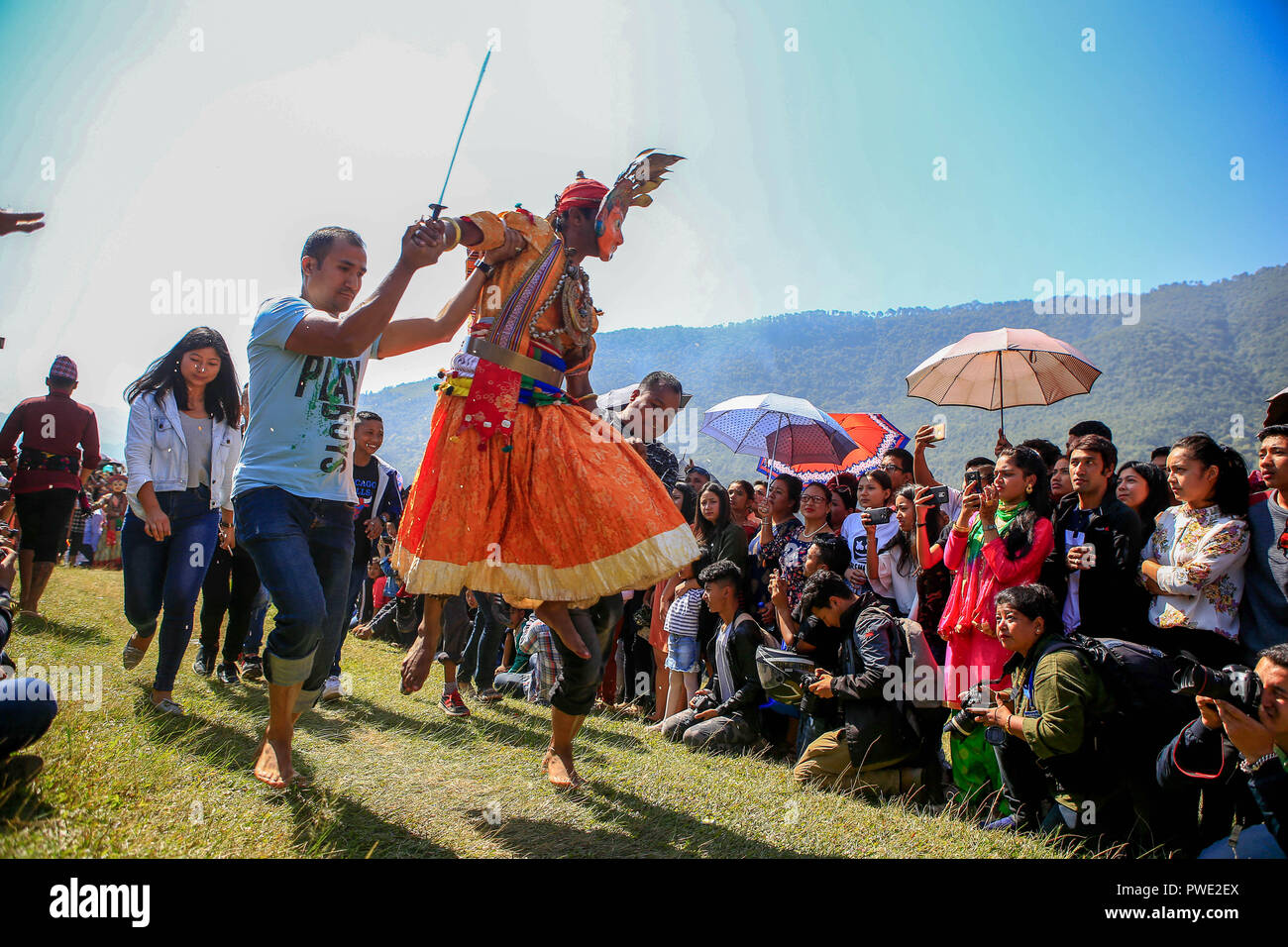 Eine Nepalesische devotee gekleidet als Gottheit springt während der Prozession von Shikali Festival. Shikali Festival 300 Jahre alt Festival feierte durch ethnische Newari Gemeinschaft von Khokana Dorf während des Festivals Anhänger tragen Masken der verschiedenen Gottheiten, Tänze aufführen, und das Opfer, Tiere in der Hoffnung, immer den Segen der Götter. Menschen bilden das Dorf Shikali Festival als Alternative von dashain Festival feiern, feiert den Sieg der Götter über das Böse. Stockfoto