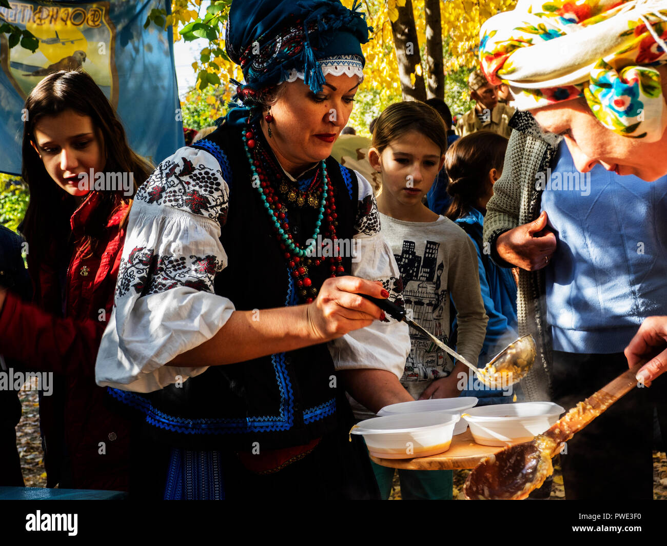 Borispol, Ukraine. 14. Okt 2018. Frauen in Trachten behandeln die Teilnehmer mit Kosak essen. - Den Schutz der Jungfrau ist ein nationaler Feiertag, der von der Ukrainischen Orthodoxen Kirche gefeiert. An diesem Tag gleichzeitig die Urlaub der ukrainischen Kosaken, der Tag der Gründung der Ukrainischen aufständischen Armee und der Tag der Verteidiger der Ukraine gefeiert. Quelle: Igor Golovnov/Alamy leben Nachrichten Stockfoto