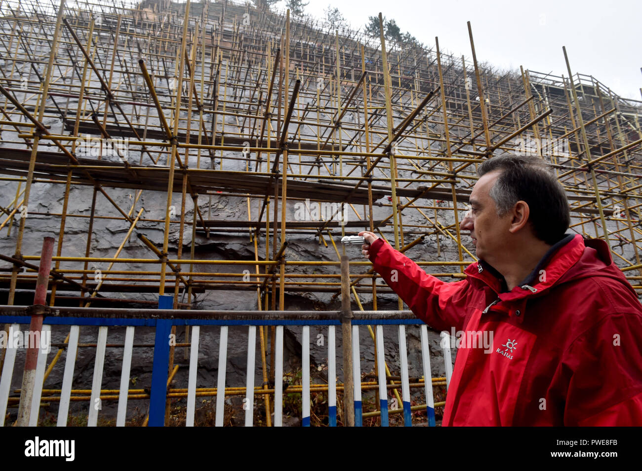 Peking, China. 15 Okt, 2018. Ilias Valiakos, ein Experte aus dem Geopark Lesbos in Griechenland, erläutert den Stand der Dinosaur footprint Erhaltung am Yanqing globale Geopark Yanqing Bezirk von Peking, der Hauptstadt von China, 15. Oktober 2018. Fachleute aus China und Griechenland haben gemeinsame Konservierungsarbeiten auf versteinerte Fußabdrücke von Dinosauriern in Yangqing begann sie von Wetter, um Beschädigungen zu vermeiden. Die Abdrücke sind vermutlich durch die Dinosaurier vor 150 Millionen Jahren gelassen zu werden. Credit: xiaoguang Luo/Xinhua/Alamy leben Nachrichten Stockfoto