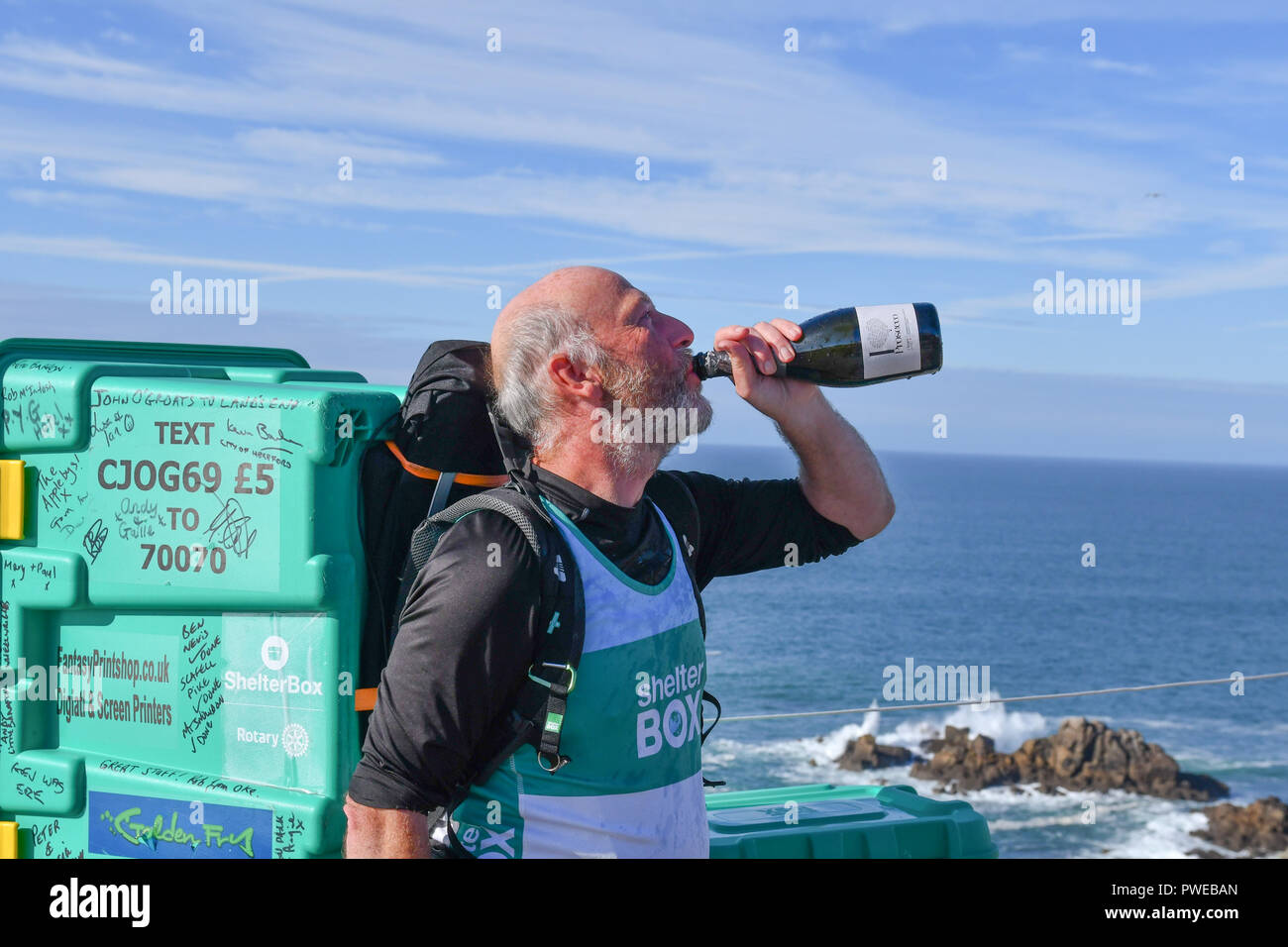 Lands End, Cornwall, UK. 16. Oktober 2018. Colin Bell hat seine epische Spaziergang von John O'Groats zu Lands End heute abgeschlossen, die eine shelterbox auf seinem Rücken. Er hat auch die drei Gipfel des Ben Nevis, Scafell Pike und snowdon enthalten, bei denen rund 1100 Meilen - in zwei Beine wegen der Verletzung. Er ist das Bewusstsein und die Mittel für die hilfsorganisation Shelterbox. Für weitere Informationen wenden Sie sich bitte an 01235 844690 Alamy newsdesk: Simon Maycock/Alamy leben Nachrichten Stockfoto