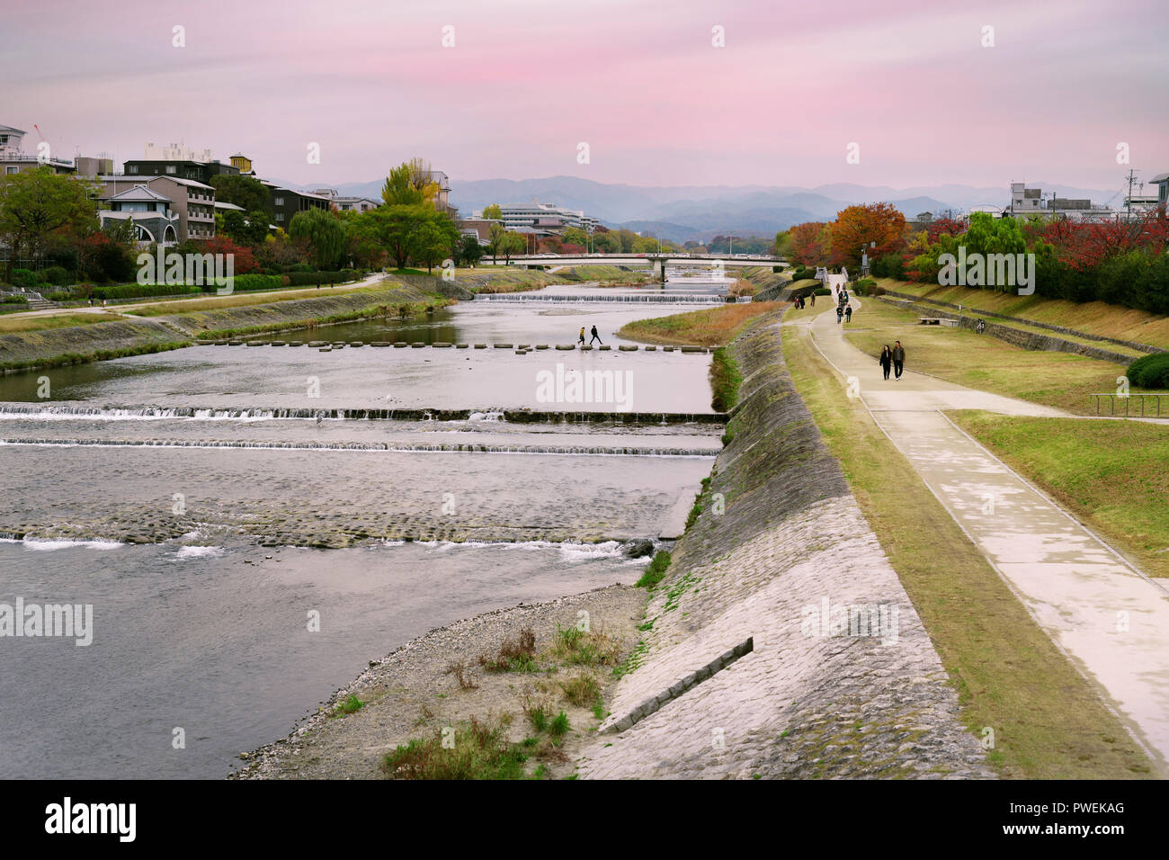 Paar Kreuzung Kamogawa, Kamo-gawa, zu Fuß auf Trittsteine, Kyoto sunset Stadt Landschaft, Japan 2017. Stockfoto