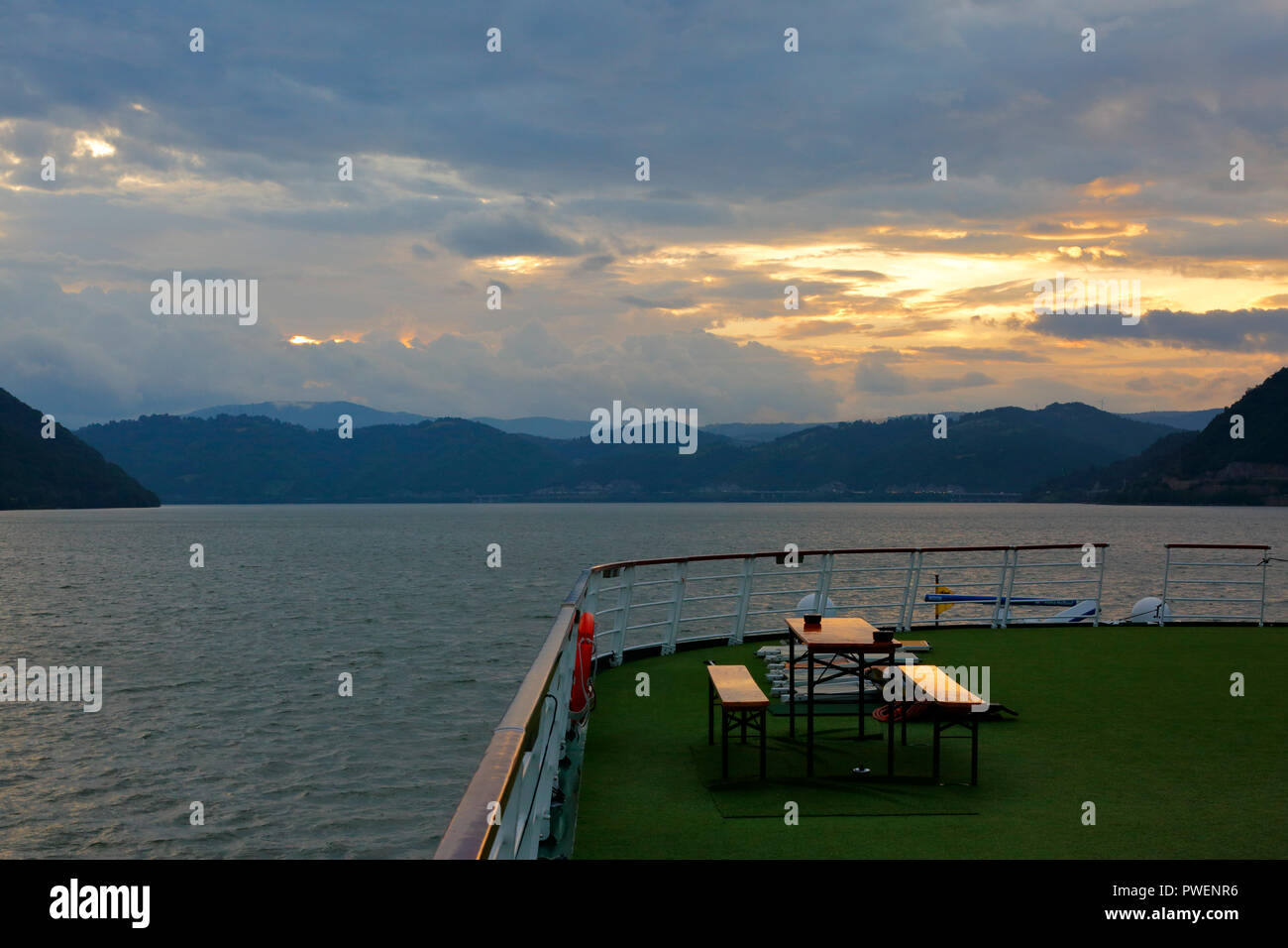 Serbien, Rumänien Südkarpaten, Serbische Karpaten, Banat Berge, Djerdap Nationalpark, Katarakte, Eisen Tore, Donau Water Gap, Flusskreuzfahrt auf der Donau, Donau Navigation, aROSA 393 Mia, Flusslandschaft, Donau Landschaft, Berge, bergige Landschaften, steilen Felsen, Abend, Sonnenuntergang, dunkle Wolken Stockfoto