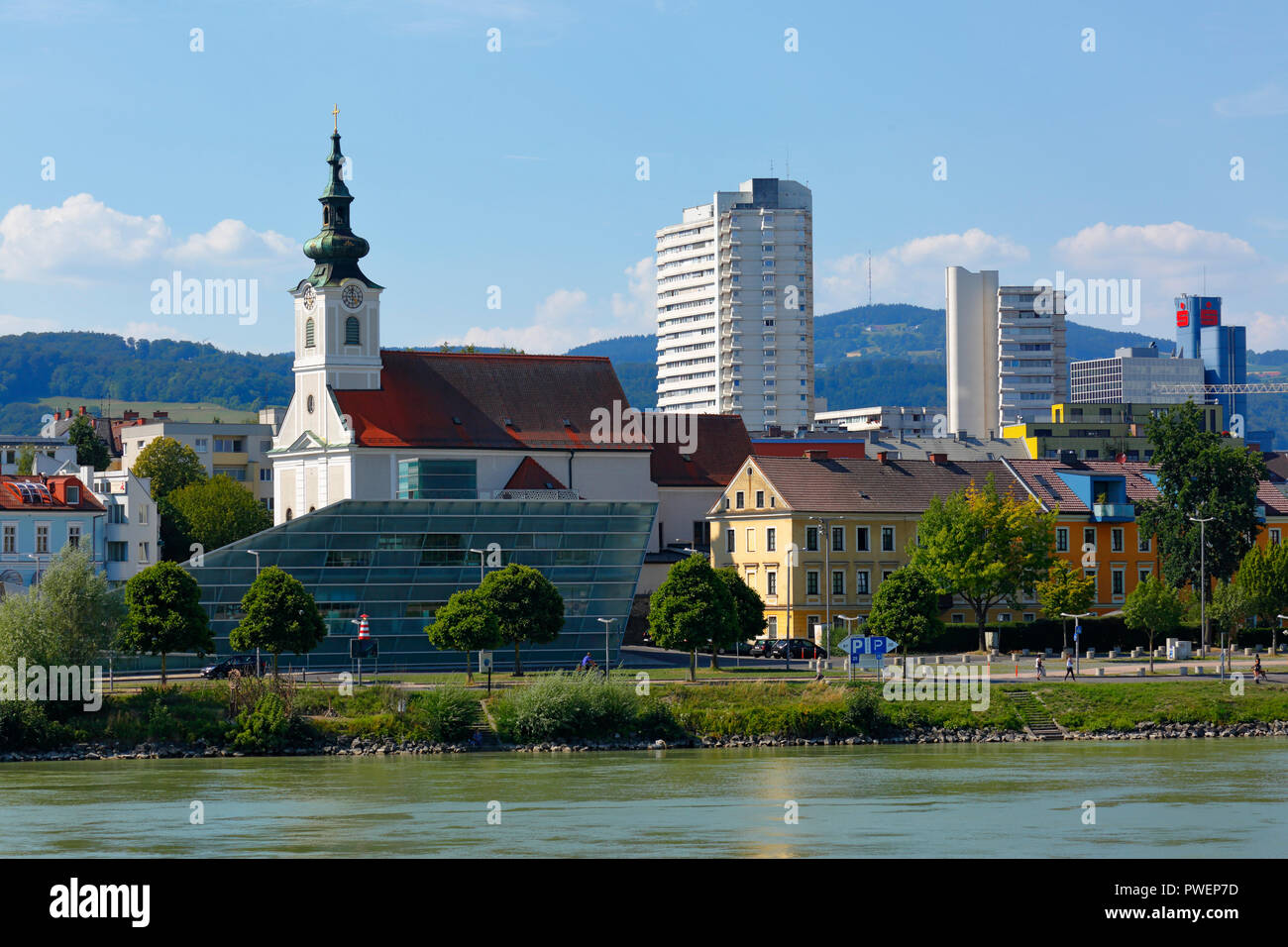 Österreich, Oberösterreich, Linz an der Donau, Landeshauptstadt von Oberösterreich, Kulturhauptstadt 2009, Blick auf die Stadt von Linz-Urfahr, Pfarrkirche St. Josef, katholische Kirche, hinter architektonischen Komplex Lentia 2000, Hochhaus, Gebäude, Wohnhäuser, Werbung, Donauufer, Riverwalk Stockfoto