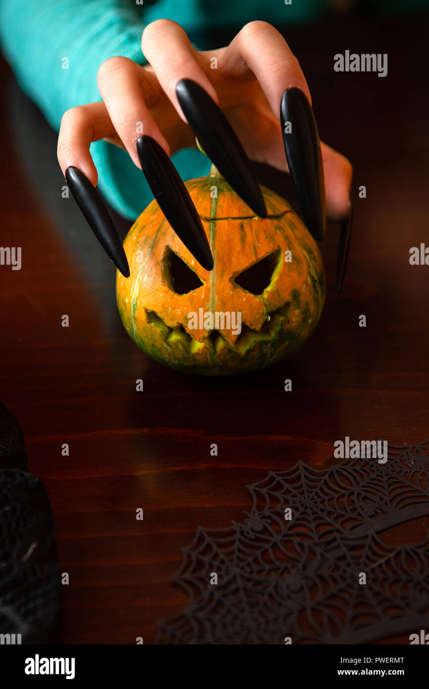 Bild der Hände des Menschen mit Kürbis Jack an den hölzernen Tisch sitzen Stockfoto