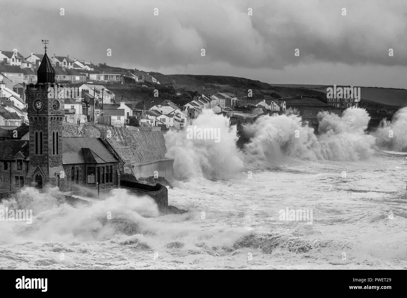 Porthleven Clock Tower Cornwall und Klippen mit großen Sturzwellen bei Winterstürmen, stürmischem Wetter, Stockfoto