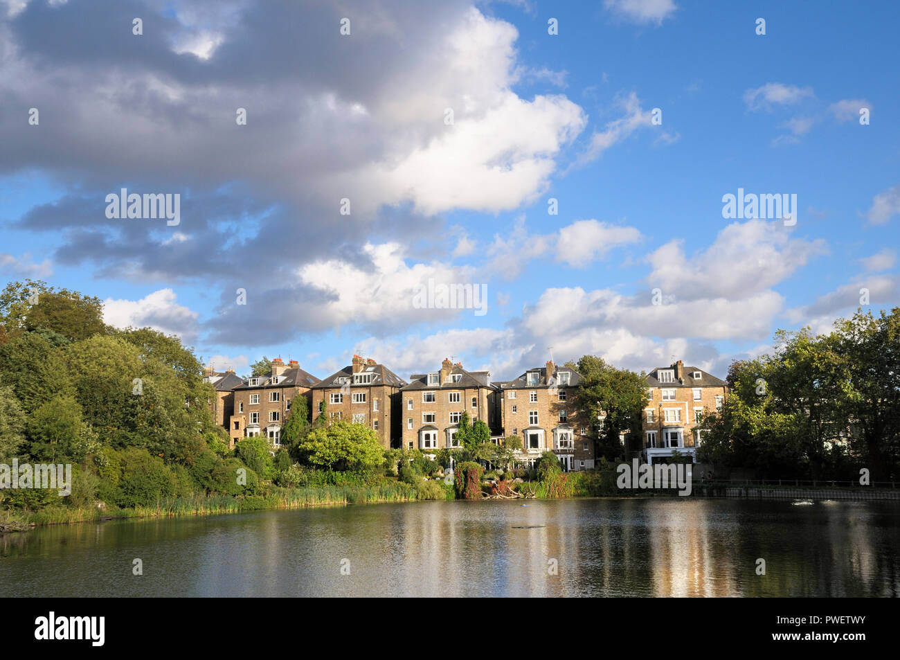 Häuser in South Hill Park mit Blick auf die Hampstead Nr. 2 Teich in Hampstead Heath, London NW3, England, Großbritannien Stockfoto