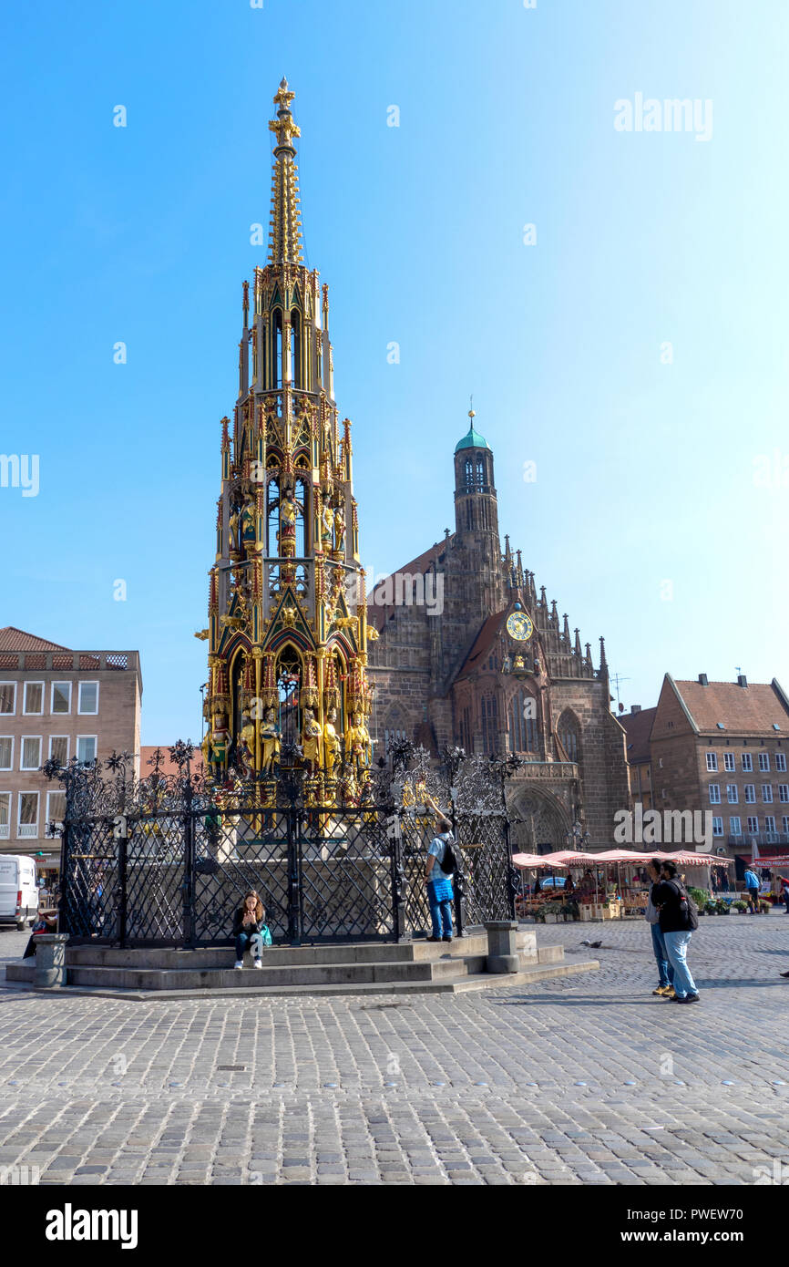 Das 14. Jahrhundert Brunnen Schöner Brunnen auf dem Hauptplatz von Nürnberg, Deutschland. Dahinter steht die Frauenkirche. Stockfoto