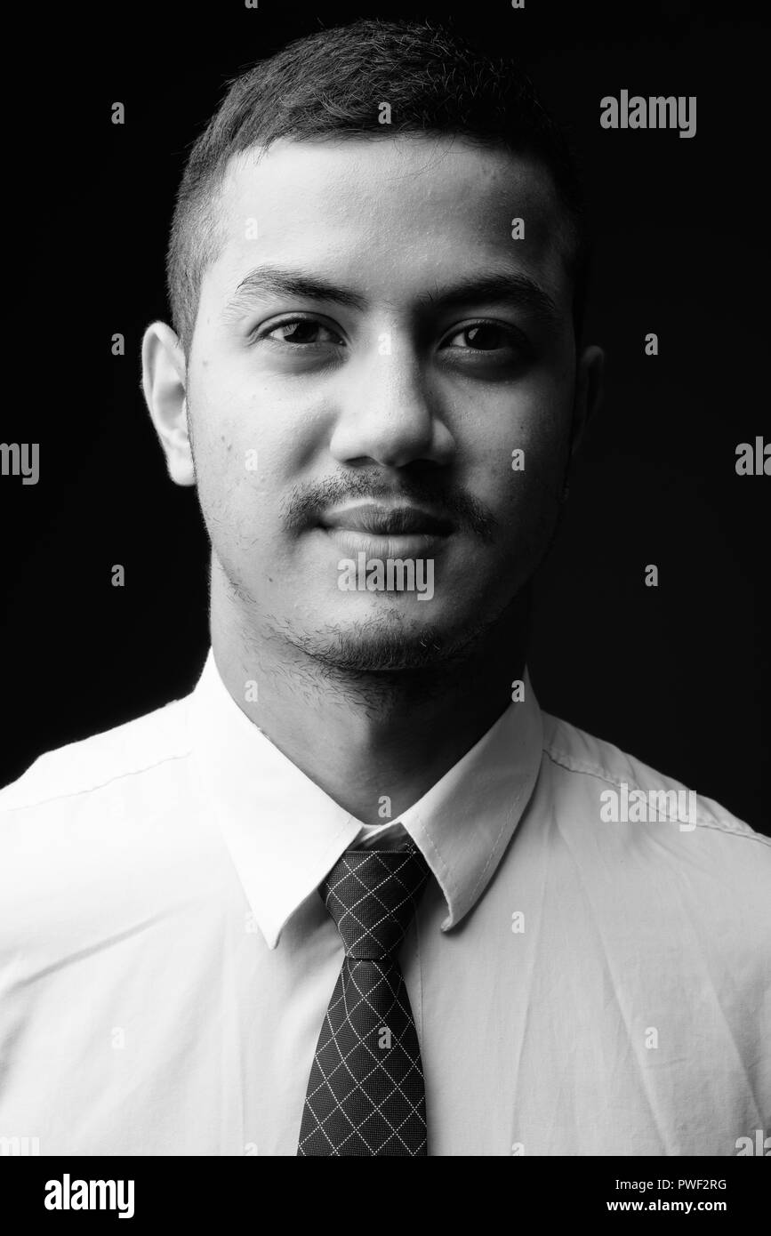 Junge multi-ethnischen asiatische Geschäftsmann gegen grauen Hintergrund in Stockfoto