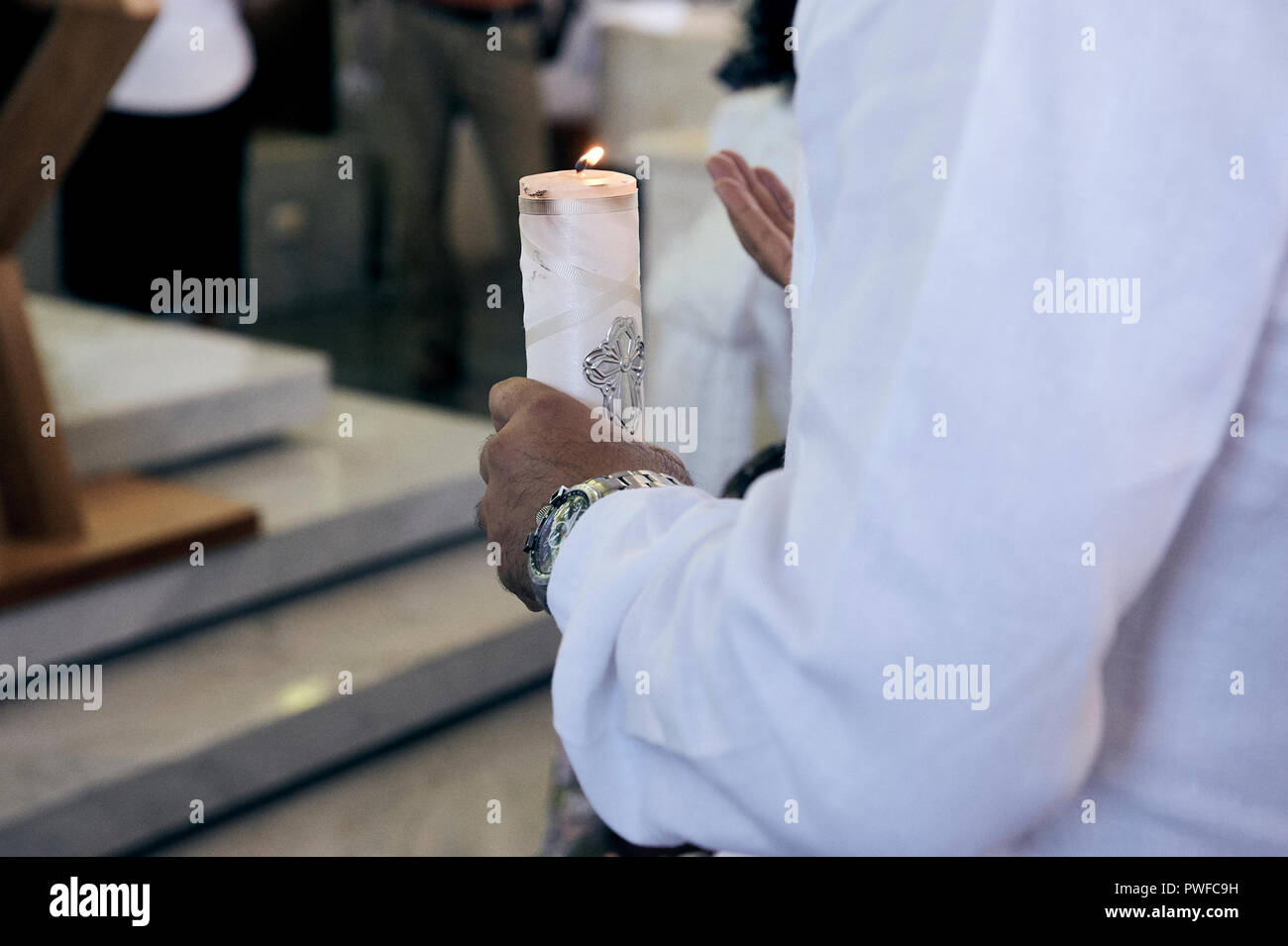 MERIDA, Yuc/MEXIKO - 18.November 2017: Pate hält Taufe Kerze während des Gebets. Stockfoto