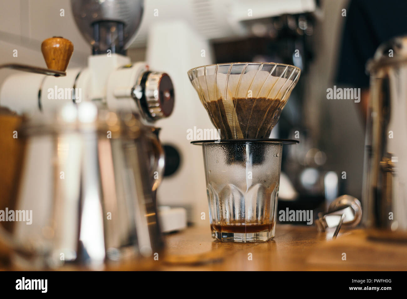Kaffee tropft auf Holztisch mit blur coffee bar Szene Stockfoto