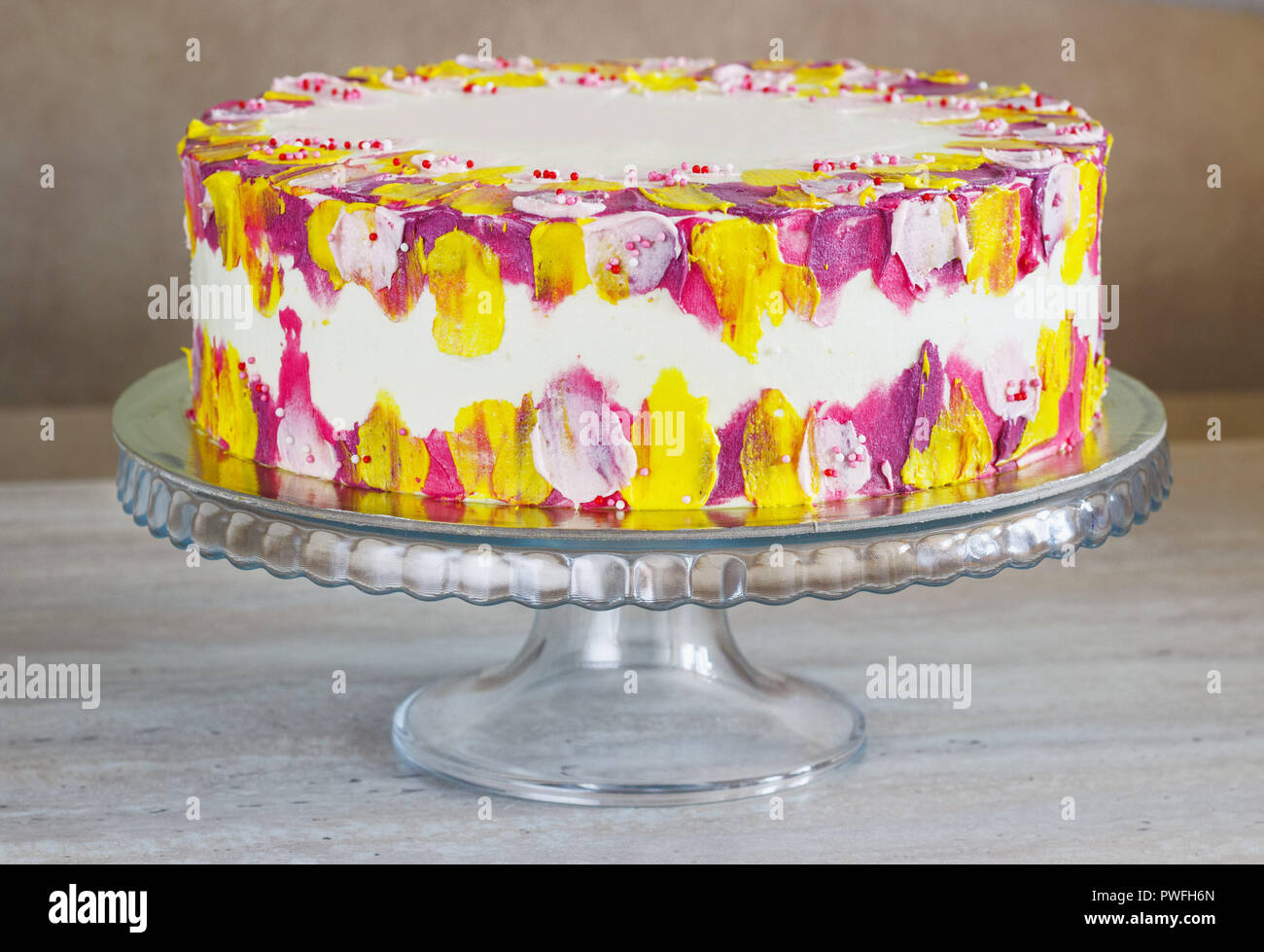 Weiß Geburtstag Kuchen mit bunten Streuseln über einen hellen Hintergrund. Stockfoto