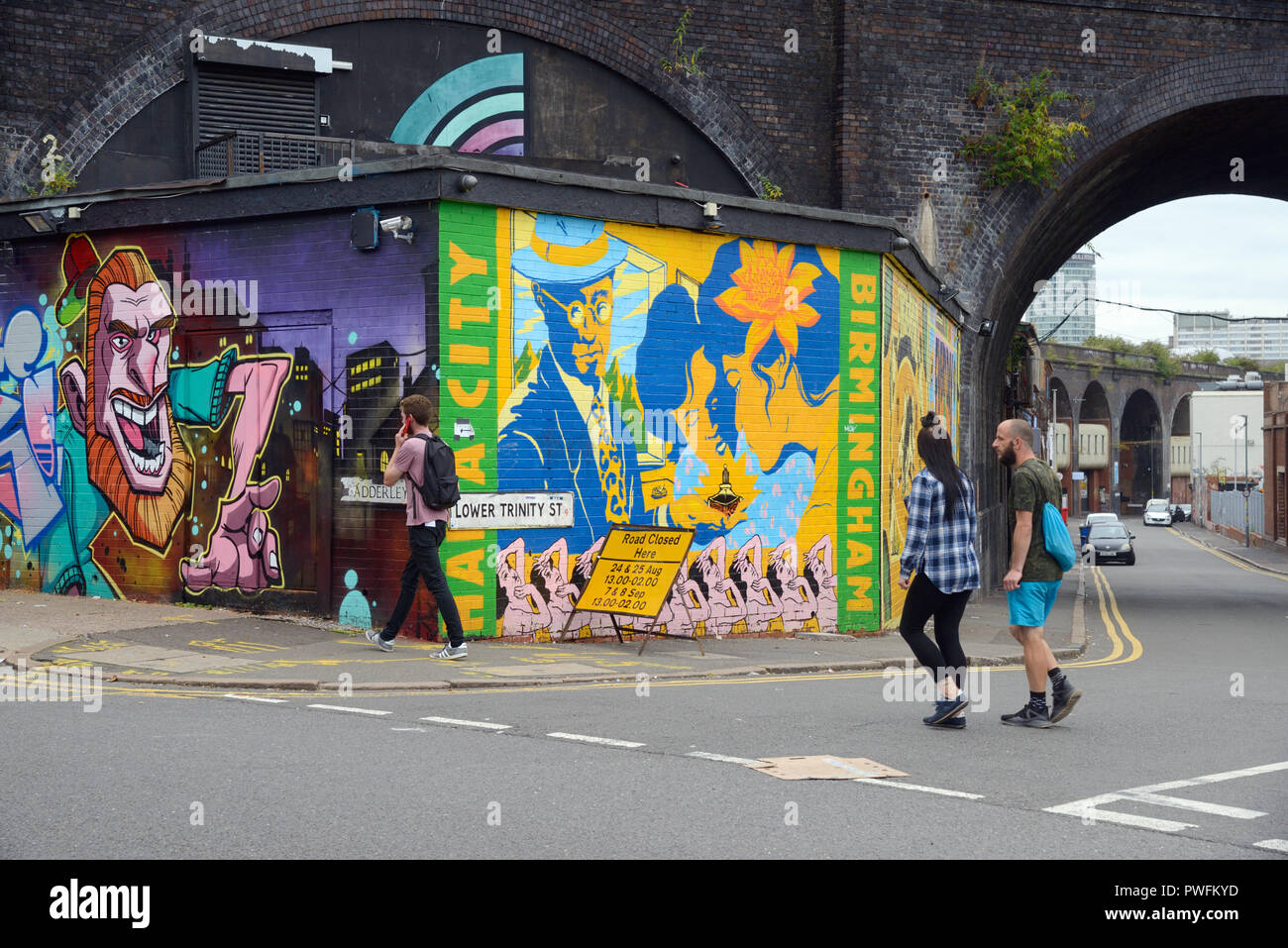 Junges Paar & Mann vorbei Street Art im Alten Run-Down Straßen von digbeth Birmingham England Stockfoto