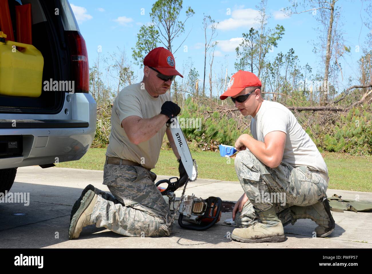 Tech, 14. Oktober 2018. Sgt. Scott Durren, Heavy Equipment operator und Älterer Flieger James Lang, Operations Manager, beide von der 202. Geben Sie der Camp Blanding, Fla. arbeiten zusammen, um eine Kettensäge zu reparieren, während die umgestürzte Bäume auf Debi Straße im Bayou George Bereich von Panama City Okt. 14, 2018 zu löschen. Die GEBEN Sie auf Für ihr Know-how in der effizienten Route clearing genannt nach dem Hurrikan Michael durch kamen. (U.S. Air National Guard Foto: Staff Sgt. Carlynne DeVine). () Stockfoto