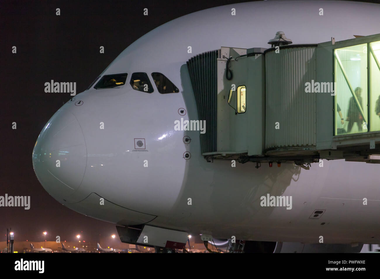 Passagiere aus dem Flugzeug abreisen. Das Flugzeug steht durch den Tunnel in der Nacht zum Flughafen. Stockfoto