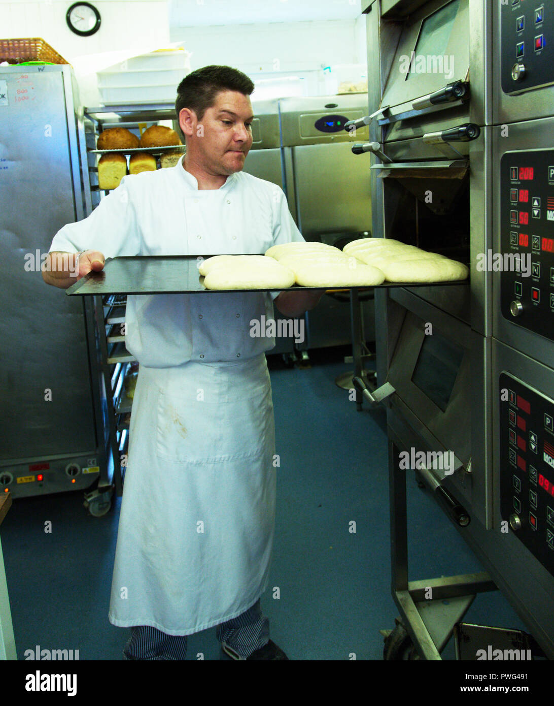 Baker Inverkehrbringen Teig Brot im Ofen. Stockfoto