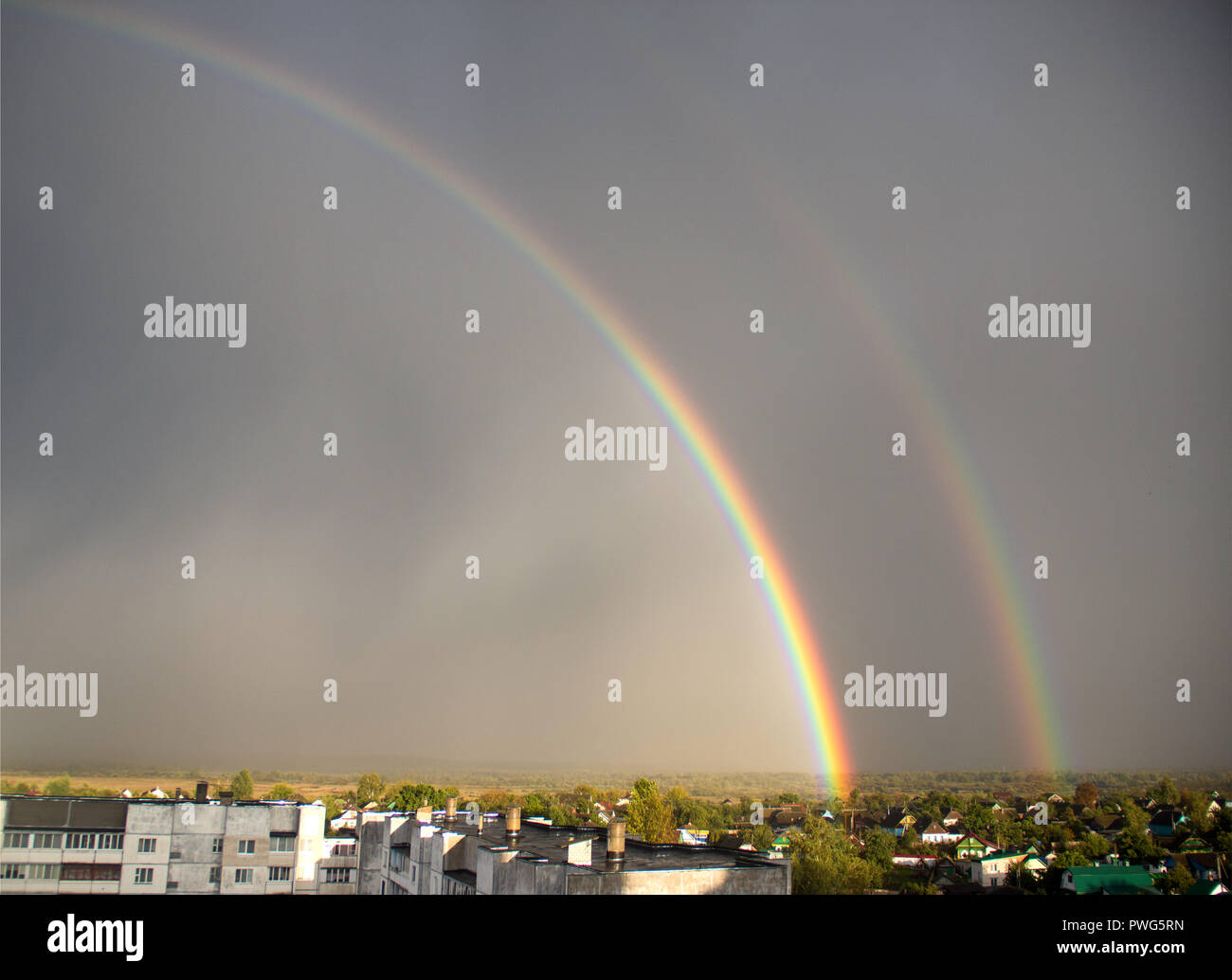 Doppelten Regenbogen über der Stadt, Wohnviertel, doppelter Regenbogen über dem blauen Himmel Stockfoto