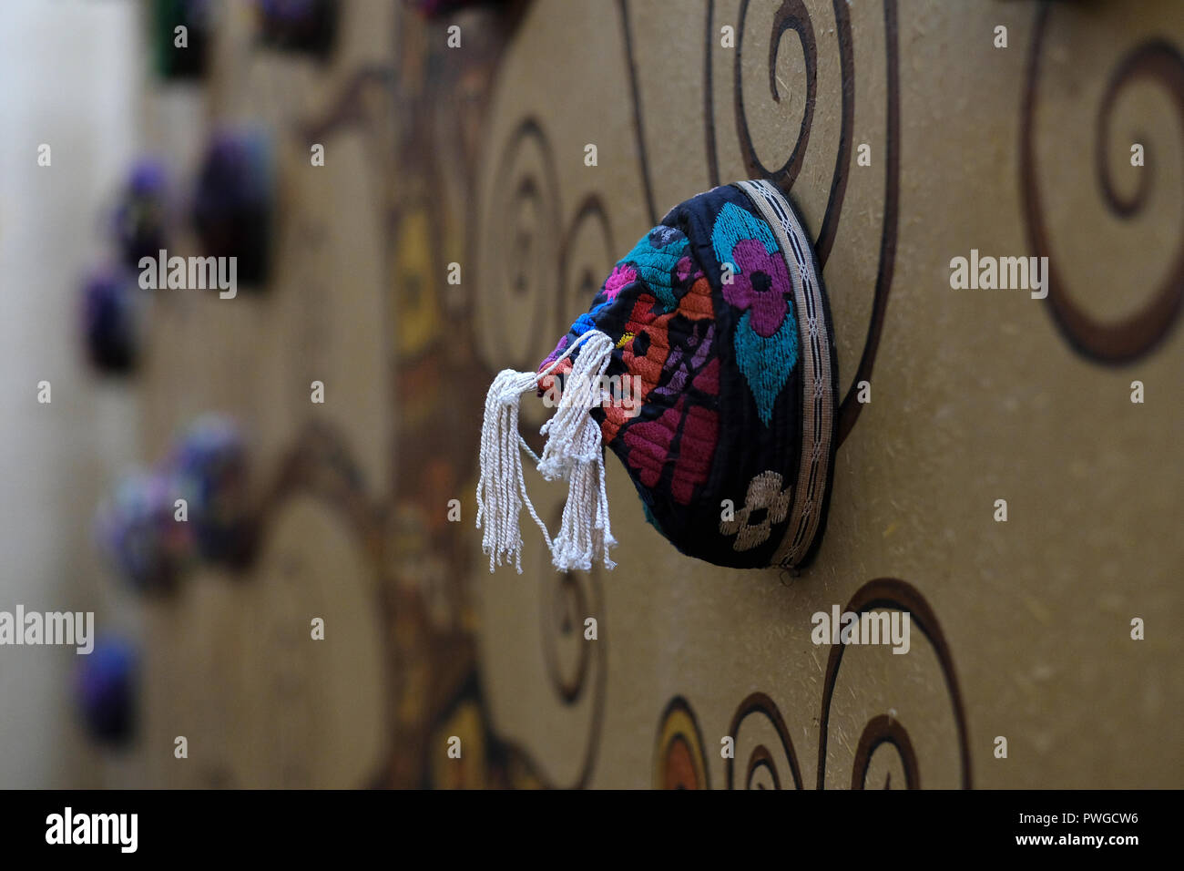 Stapel von Tubeteika oder Tubatay traditionellen Kappen getragen in Tadschikistan, Kasachstan, Kirgisistan und Usbekistan verzieren die Mauer von Xan Atlas Restaurant in der Stadt Samarkand alternativ Samarkand in Usbekistan Stockfoto
