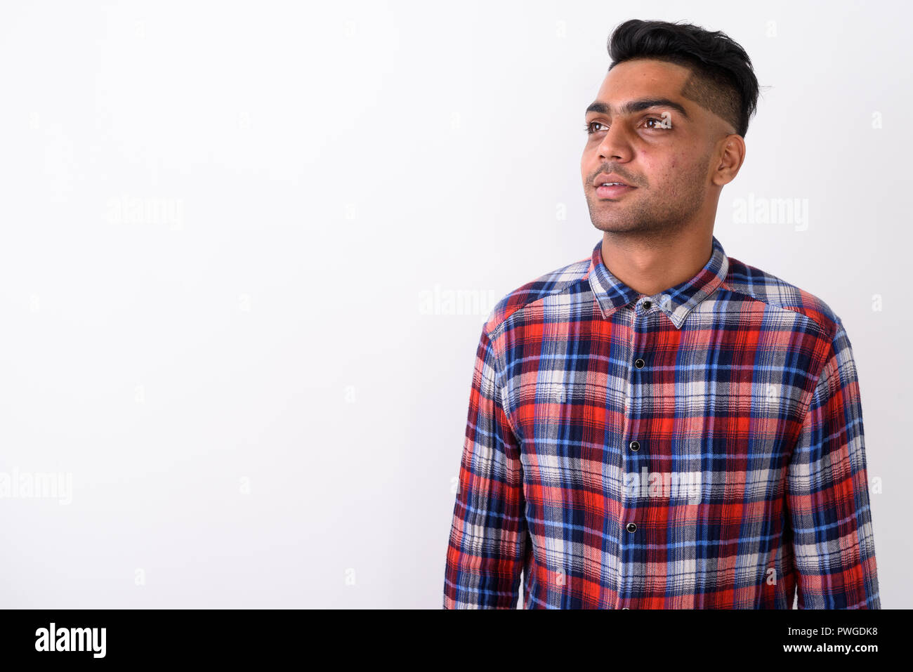 Junge indische Mann mit kariertem Hemd gegen Weiße backgroun Stockfoto