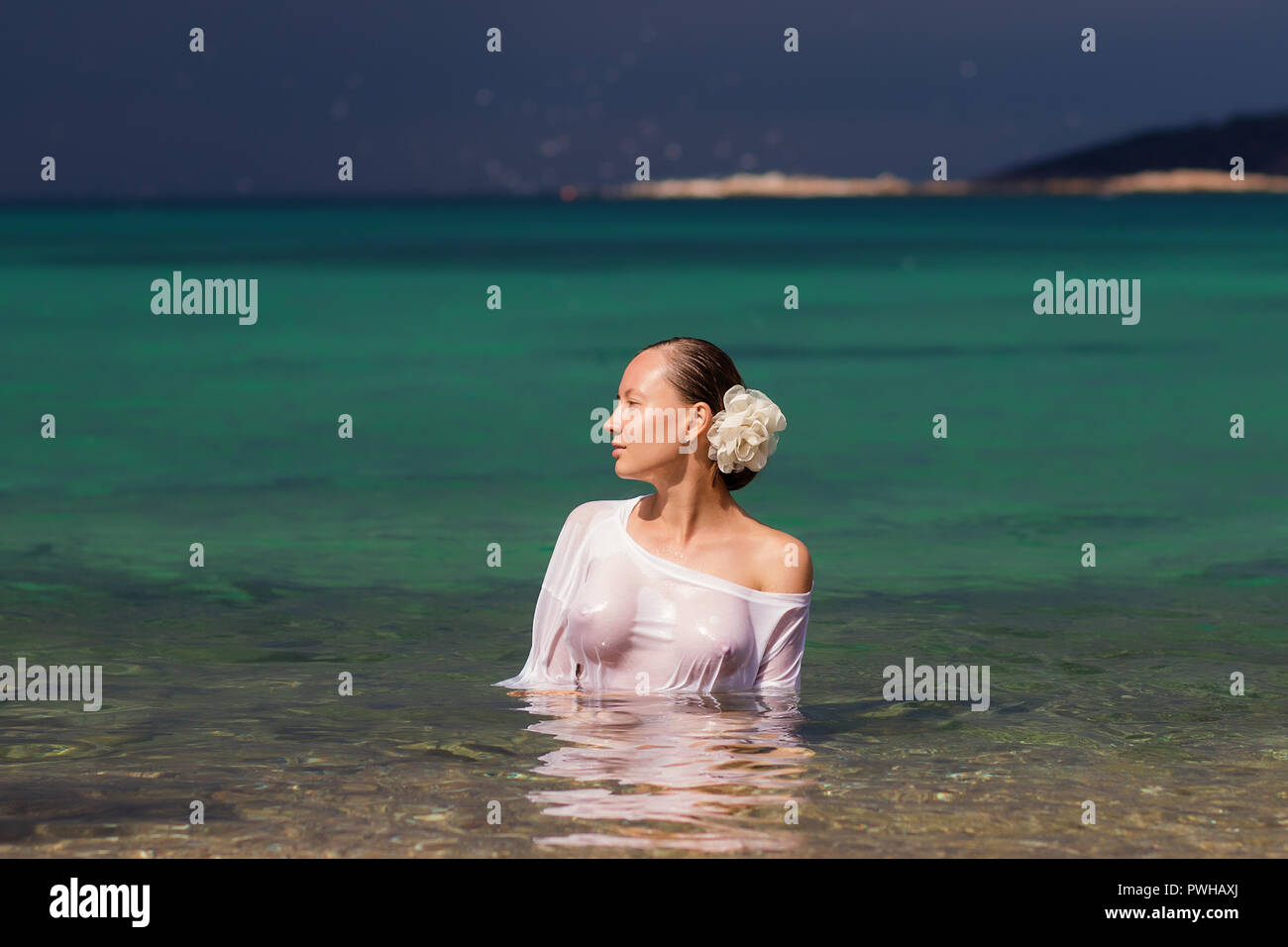 Sinnliche junge Frau in nassen Bluse in sauberem Meerwasser und Wegsehen  Stockfotografie - Alamy